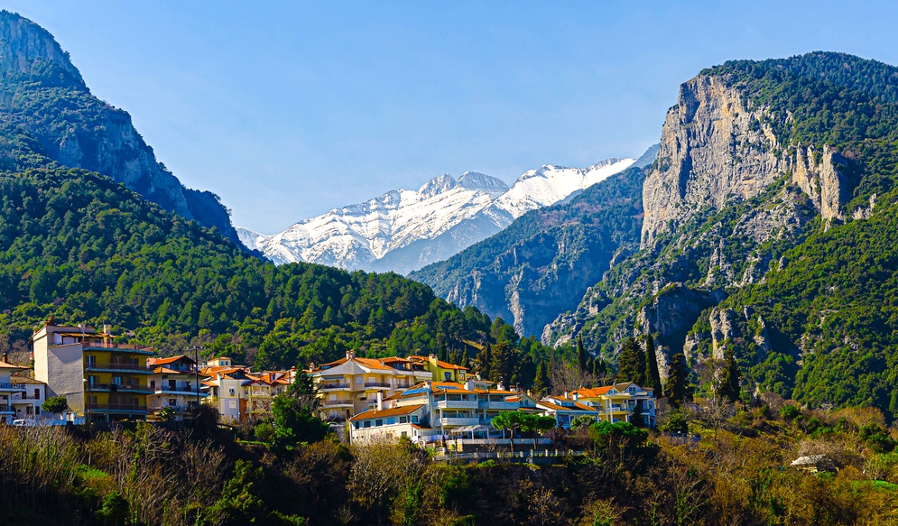 Beautiful view of the mountains of Olympus from an observation deck in the center of Litochoro. High rocky green mountains and snow-capped peaks. A small cozy village in the mountains.