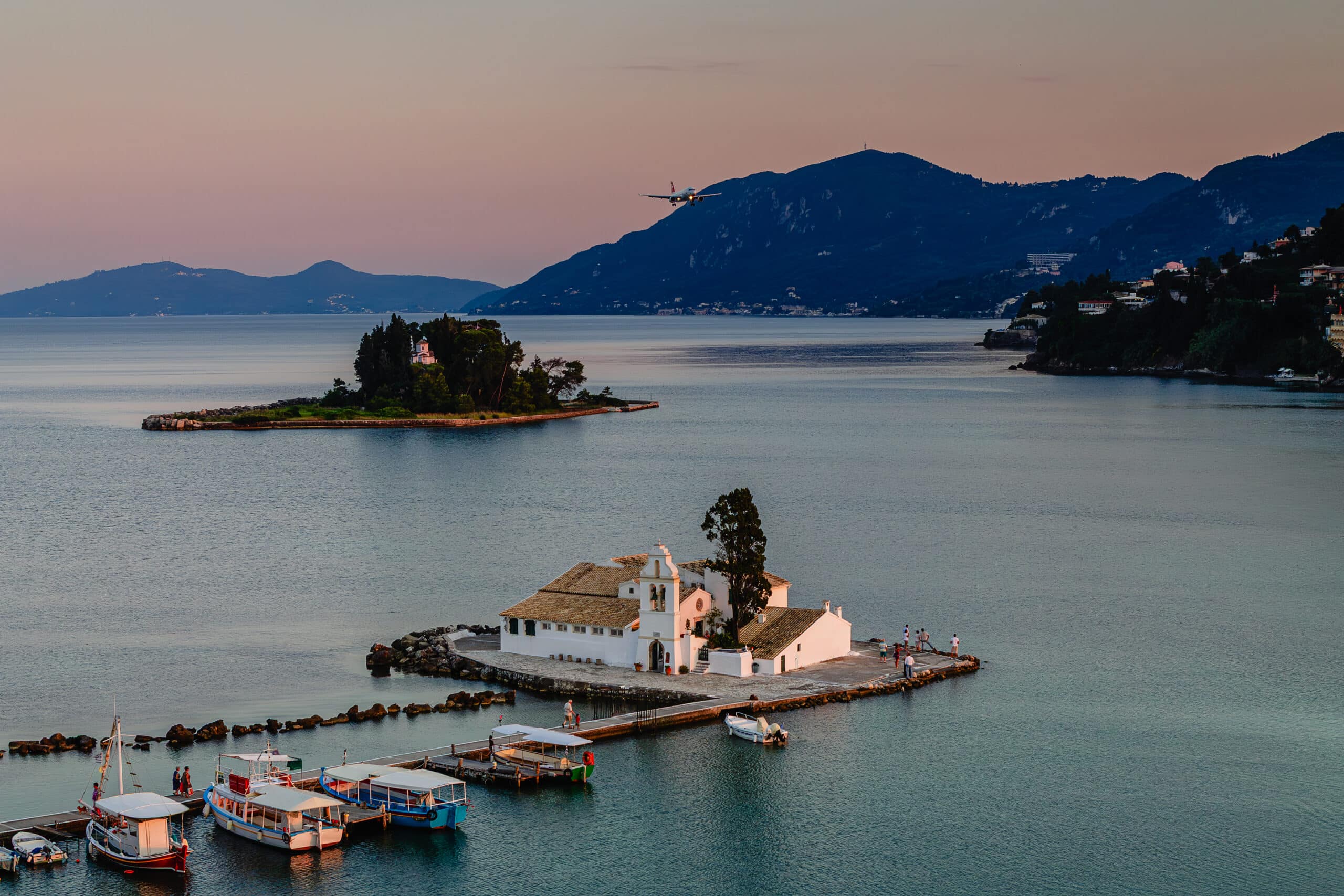Typical view of Vlacherna Monastery and Mouse island with airplane landing, Corfu, Greece.